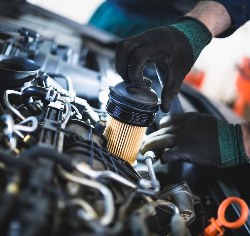 Close up hands of unrecognizable mechanic doing car service and maintenance. Oil and fuel filter changing.