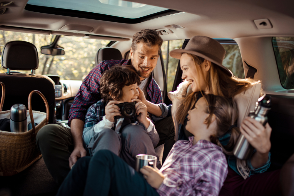 Pre-Trip Inspection Checklist in Buffalo, NY at Total Automotive. Image of a family seated inside a car, enjoying a road trip with passengers safely seated and engaged, highlighting the importance of reliable vehicles, comfortable interiors, and safe travel for families.