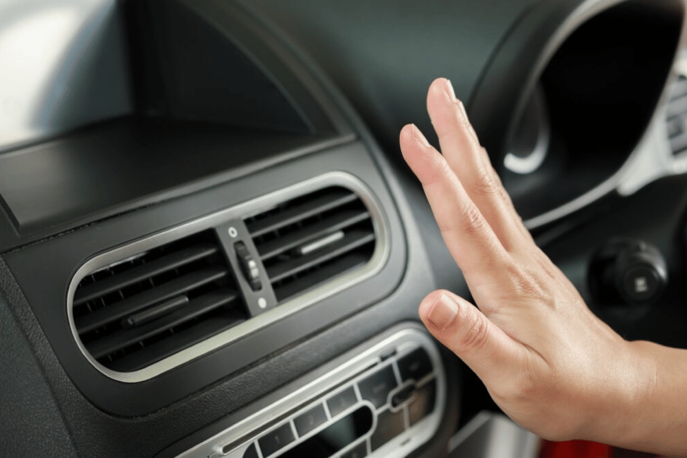 air conditioning repair in Buffalo, NY by Total Automotive -- a hand checking a car's air conditioning airflow